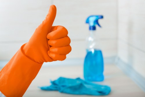 Cleaner in Highbury following safe manual handling and floor safety procedures